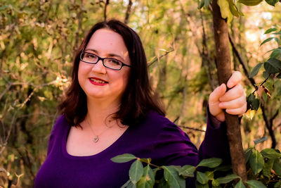 Portrait of young woman against plants