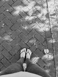 Low section of woman standing on footpath