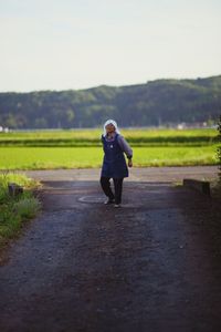 Rear view of woman standing on field