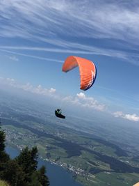 Low angle view of man paragliding in mid-air