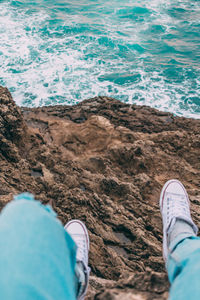 Low section of man standing on beach