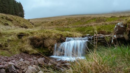 Scenic view of waterfall against sky