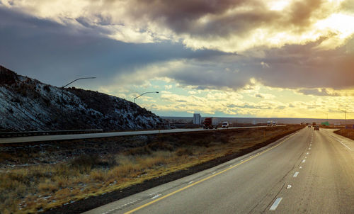 Road leading towards highway against sky