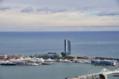 High angle view of sea by cityscape against sky, barcelona 