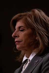 Close-up portrait of woman against black background