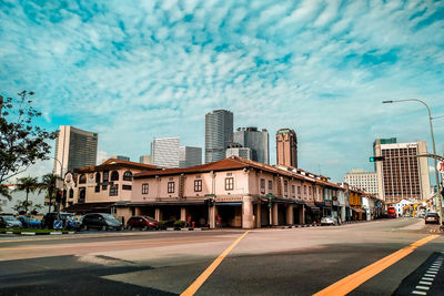 View of city street and buildings against sky