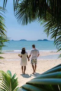 Rear view of woman walking on beach