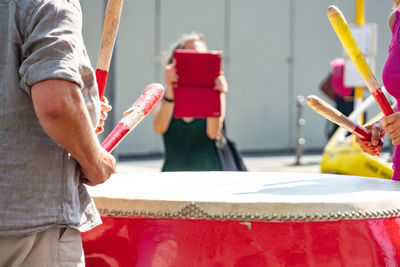 Woman photographing people playing drum