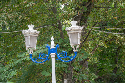 Low angle view of street light against trees