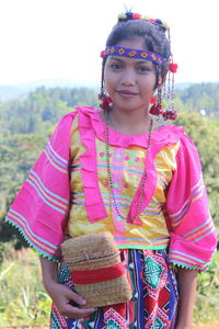 Portrait of girl in traditional clothing standing on field