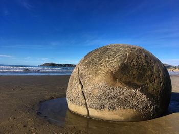 Close-up of rocks on beach against sky