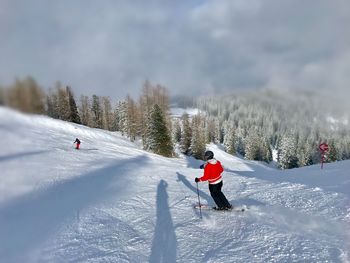 High angle view of woman skiing on mountain against sky