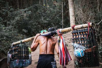 Rear view of man standing on clothesline
