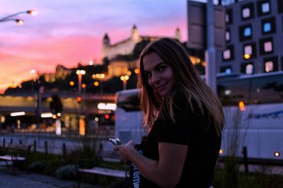 Young woman using mobile phone in city