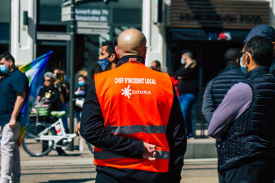 Rear view of people walking on street in city