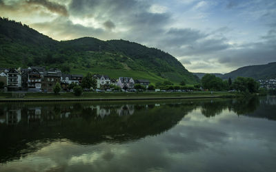 Scenic view of lake by buildings against sky