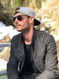 Young man wearing sunglasses while sitting outdoors