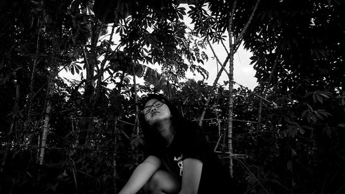 Young woman sitting amidst plant