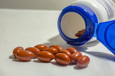 Close-up of pills by bottle on table