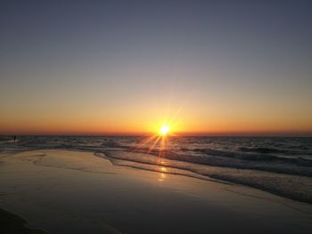 Scenic view of beach against clear sky during sunset