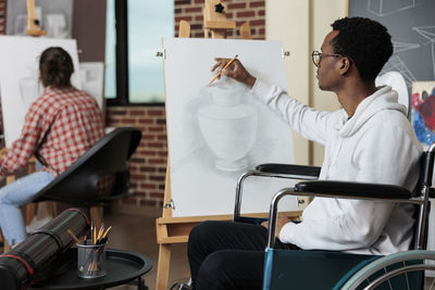 Disabled man sketching in classroom