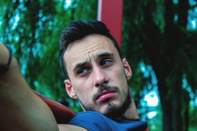 Close-up of young man against trees