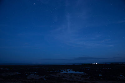 Scenic view of sea against blue sky at night