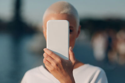 Close-up portrait of man holding mobile phone