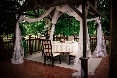 Empty chairs and tables in restaurant by garden