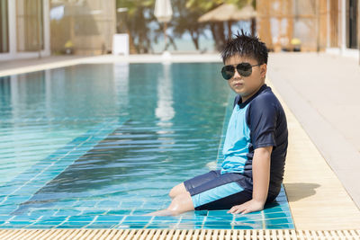 Young man using mobile phone in swimming pool