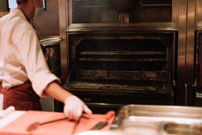 Midsection of man working in kitchen