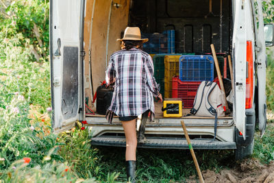 Rear view of woman standing by van