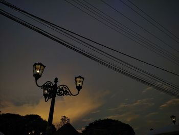 Low angle view of silhouette street light against sky