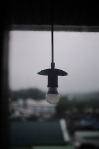 Close-up of light bulb hanging against ceiling