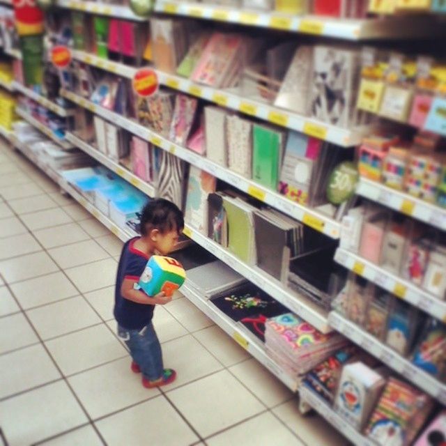 indoors, lifestyles, casual clothing, leisure activity, childhood, retail, standing, multi colored, full length, store, elementary age, boys, focus on foreground, variation, choice, front view, selective focus, person