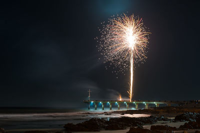Firework display over sea against sky at night. fireworks set off from shark rock pier, gqeberha