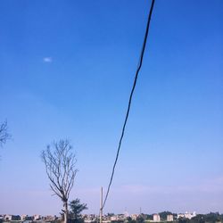 Low angle view of power lines against clear blue sky