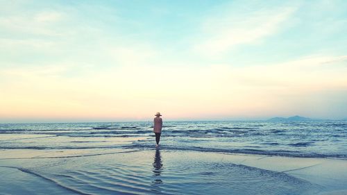 Women  standing on beach against sky