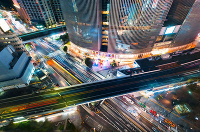 High angle view of illuminated city street and buildings at night