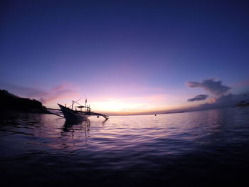 Silhouette boat in sea against sky during sunset