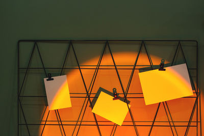 Low angle view of yellow flags hanging against orange sky