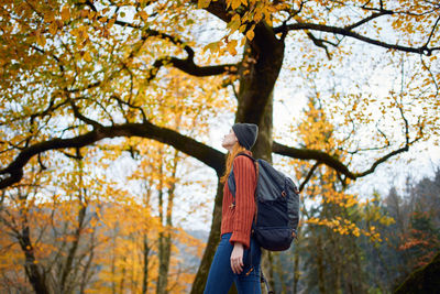 Low angle view of person standing by tree during autumn