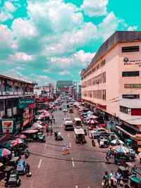 High angle view of vehicles on road by buildings in city