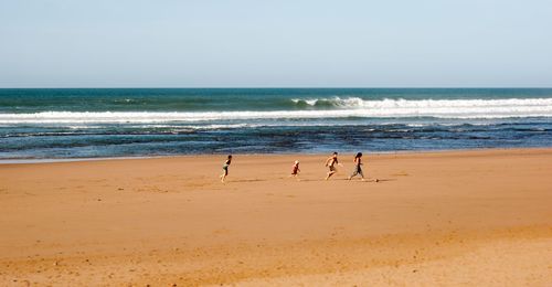 People at beach against sky