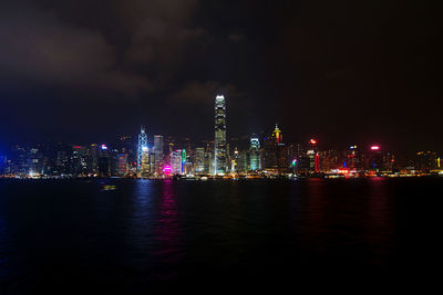 Illuminated buildings in city against sky at night