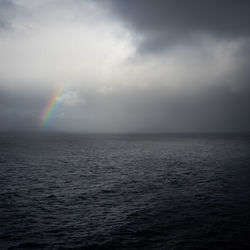 Scenic view of rainbow over sea against sky