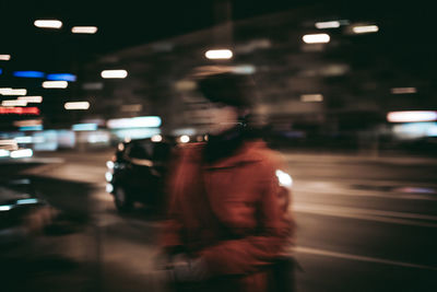 Rear view of man standing on road at night