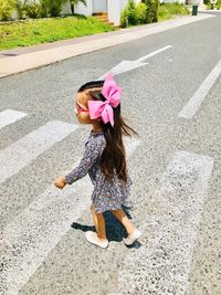 High angle view of girl with umbrella on road