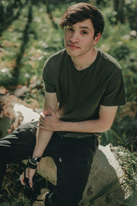 Portrait of young man sitting on land
