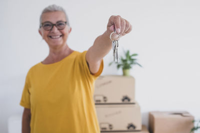 Portrait of smiling woman holding key at home